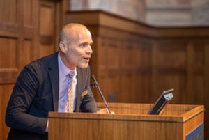 "Steve Greenfield speaking at a podium"