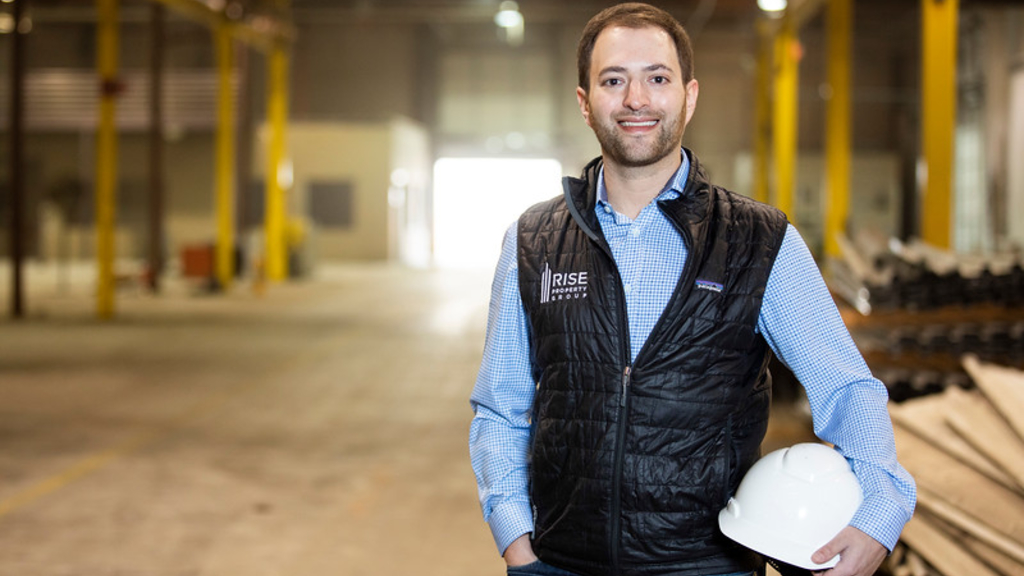 Jason Chaliff 18EvMBA standing in a warehouse holding a hardhat