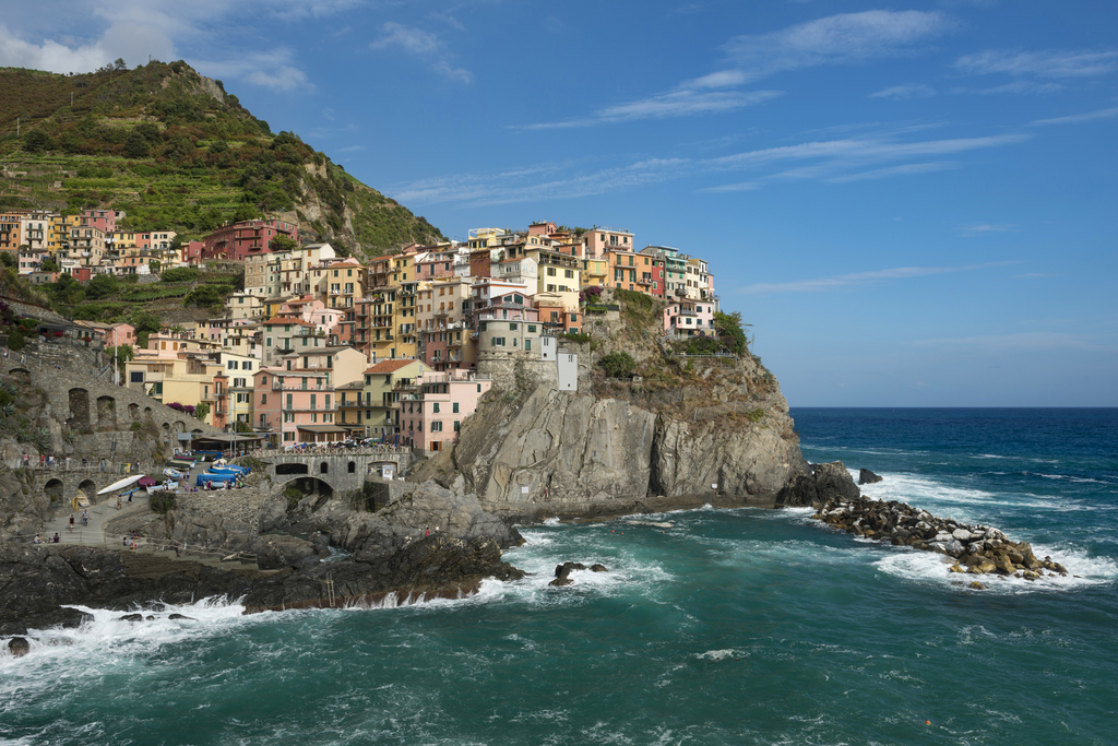Italian city built into the side of a hill against the backdrop of the sea